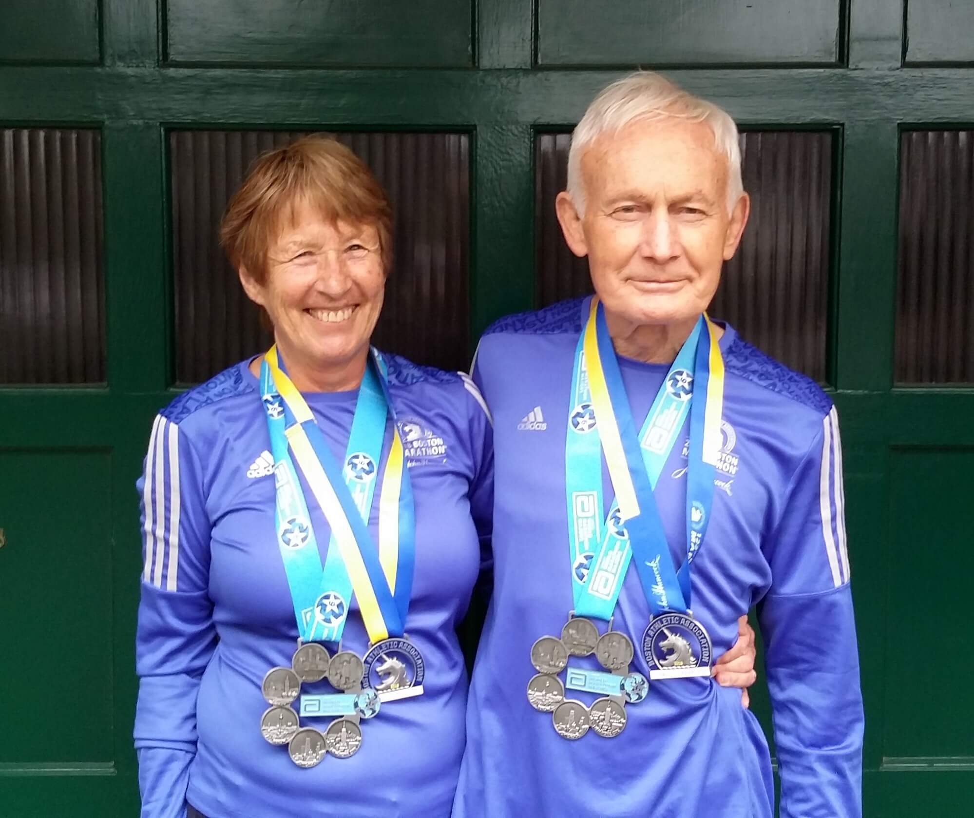 Jane and Terry celebrating completing the big 5 marathons with their medals